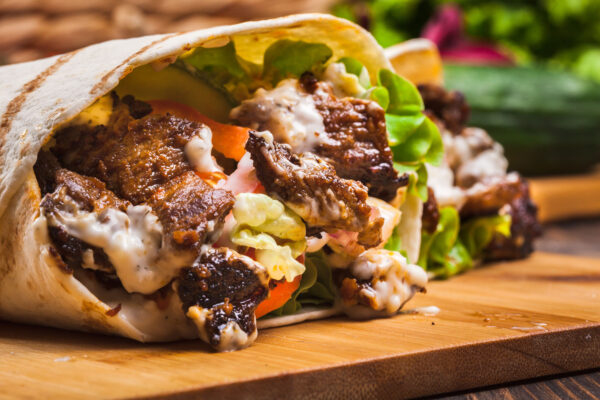 Steak Shawarma Wrap Lunch Box: Tender steak shawarma wrapped in a pita with lettuce, tomato, and garlic sauce.